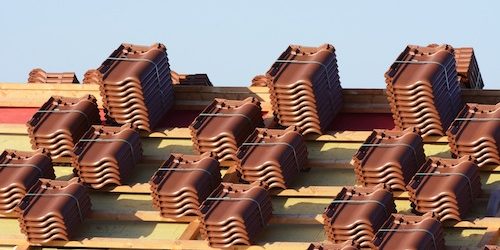 Renovation of a house roof with stacks of roof tiles